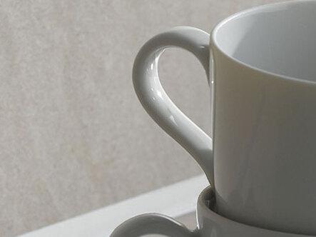 Detailaufnahme einer Spülecke mit heller Arbeitsplatte und Geschirr